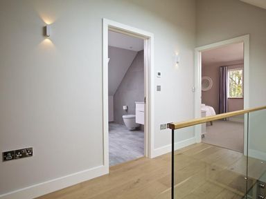 A hallway with wooden floor leading to a bathroom and bedroom at 3 The Drive Hillfield Village Dartmouth