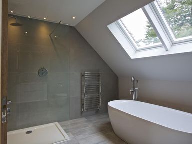 A bathroom with a freestanding bathtub a walk in shower and skylight windows at 3 The Drive Hillfield Village in Dartmouth