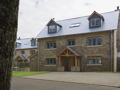 A stone house with wooden porch and multiple windows at 3 The Drive Hillfield Village in Dartmouth