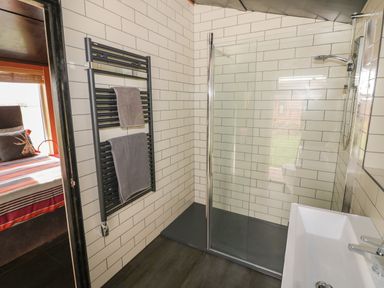 A bathroom with a walk-in shower a towel rack with towels and a sink at The Tractor Shed in Lower Broadheath Worcester
