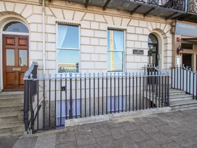 A building facade with two entrances and iron railings in front at Bliss On The Bay in Weymouth