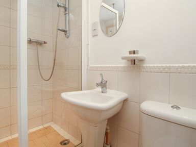 A bathroom with a shower stall a sink mirror and toilet at Bliss On The Bay in Weymouth