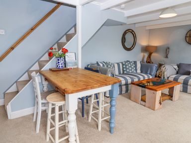 A living room with a table and chairs at 2 Cliff Cottages in West Portholland near Gorran Haven