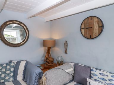 A living room with a lamp and decorative items at 2 Cliff Cottages West Portholland near Gorran Haven