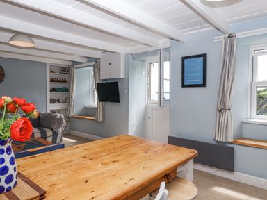 A dining room with a wooden table and chairs at 2 Cliff Cottages West Portholland near Gorran Haven