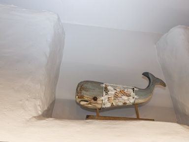 A whale decoration with shells on a wooden stand at 2 Cliff Cottages in West Portholland near Gorran Haven