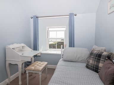 A bedroom with a desk, chair, and a window at 2 Cliff Cottages West Portholland near Gorran Haven