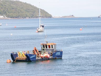 A work boat and a sailboat on water near a forested shoreline at 22 Gwel Yr Wyddfa in Menai Bridge