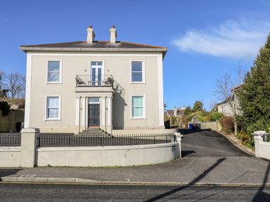 A two-story house with a side driveway and a small balcony at Sea Breeze in Ballycastle