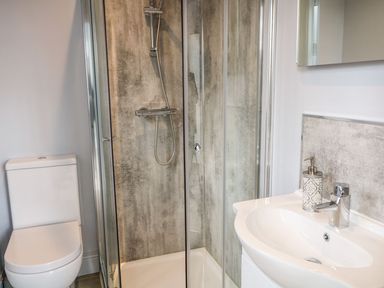 A bathroom with a toilet a shower enclosure and a sink at Sea Breeze in Ballycastle