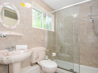 A bathroom with a toilet sink shower and a window at Dart Lodge in Callington