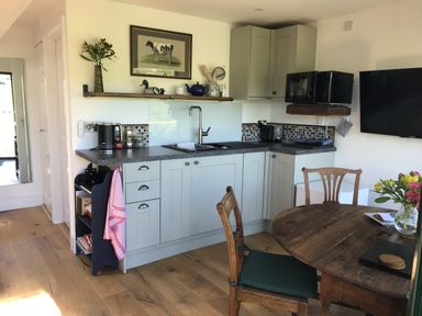 A kitchen with a dining table and appliances at The Sett on the Wharfe Skipton