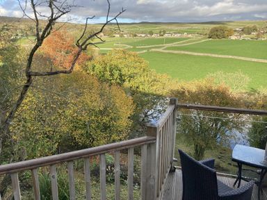 A balcony with a table and chair overlooking a landscape at The Sett on the Wharfe in Skipton