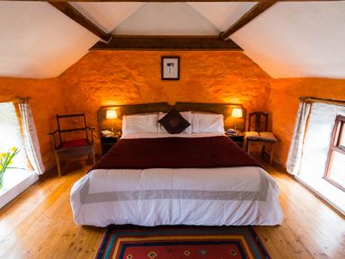 A bedroom with a large bed and two bedside tables with lamps at The Stable in Fethard-On-Sea County Wexford