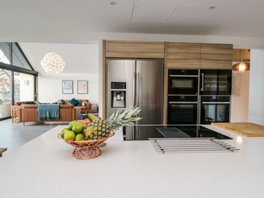 A kitchen with a fruit bowl on a white countertop and stainless steel appliances at Kessock in Bowness-On-Windermere