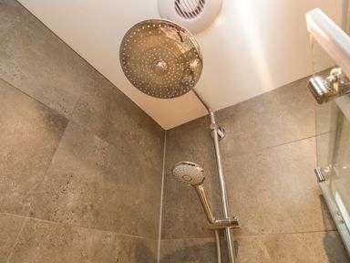 A shower area with two showerheads and a ventilation fan at Kessock in Bowness-On-Windermere