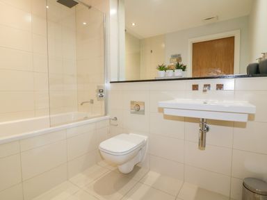 A bathroom with a bathtub shower toilet and sink at Fistral Apres Surf in Newquay