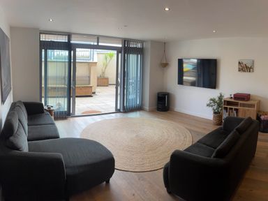A living room with a sofa and television at Fistral Apres Surf in Newquay