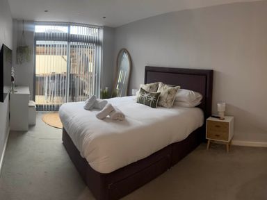 A bedroom with a bed and mirror at Fistral Apres Surf in Newquay
