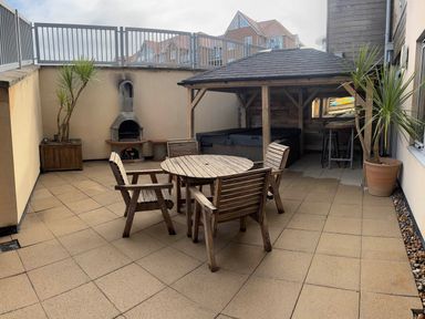 An outdoor area with a wooden table and chairs plus a hut at Fistral Apres Surf in Newquay