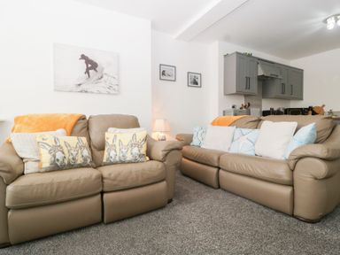 A living room with two sofas and wall decor at 76A Mackworth Road in Porthcawl
