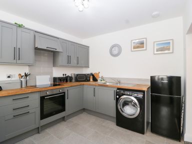 A kitchen with grey cabinets and appliances at 76A Mackworth Road Porthcawl