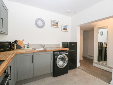 A kitchen with a washing machine and refrigerator at 76A Mackworth Road in Porthcawl