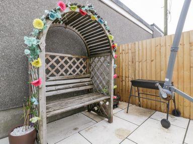 A garden arch with a bench and grill at 76A Mackworth Road Porthcawl