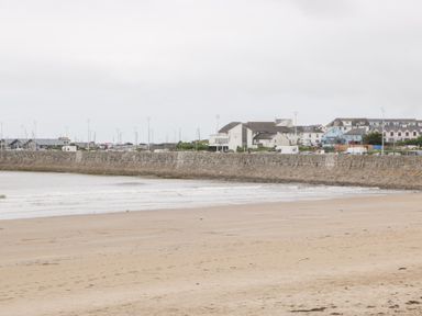 A beach with water and buildings in the distance at 76A Mackworth Road Porthcawl