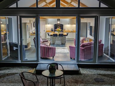 A living room and kitchen with chairs and a table outside at The Old Vicarage Retreat in Luxulyan