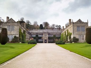 A large stone manor house with manicured lawns and a gravel driveway at The Old Vicarage Retreat in Luxulyan