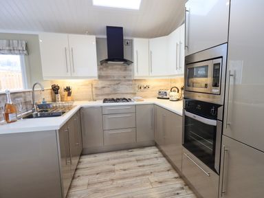 A kitchen with sink stove oven microwave and cabinets at Lakeland View Lodge Beckside 2 Limefitt Park near Windermere