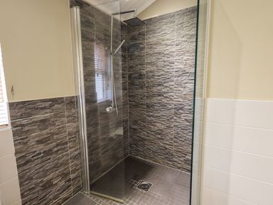 A walk in shower with stone wall tiles and a glass divider at Lakeland View Lodge Beckside 2 Limefitt Park near Windermere