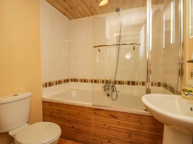 A bathroom with a toilet sink bathtub and shower at Damson Lodge Thirlmere 8 White Cross Bay Windermere