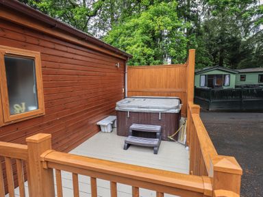 An outdoor area with a hot tub and wooden deck at Ridgway Lodge, Calgarth 40, White Cross Bay near Windermere