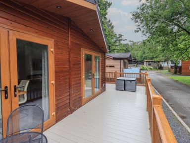An outdoor area with a wooden deck and table at Ridgway Lodge, Calgarth 40, White Cross Bay near Windermere