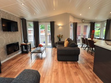 A living room with a sofa and dining table at Rydal Lodge Grasmere 24, White Cross Bay near Windermere