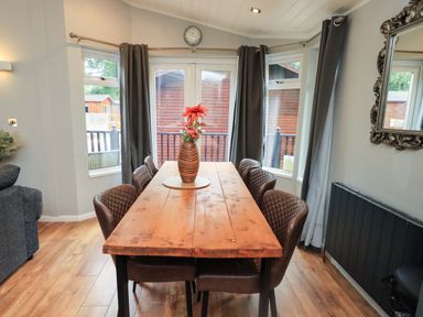 A dining room with a wooden table and chairs at Rydal Lodge in Grasmere 24, White Cross Bay near Windermere