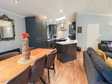 A kitchen with dining table and sofa at Rydal Lodge, Grasmere 24, White Cross Bay near Windermere
