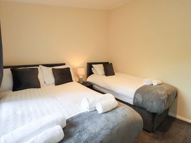 A bedroom with two beds and a lamp at Rydal Lodge Grasmere 24, White Cross Bay near Windermere