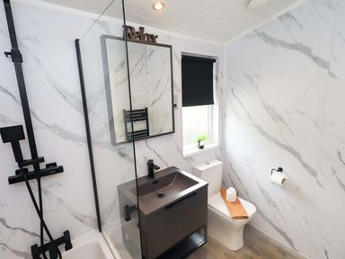 A bathroom with a shower, sink and toilet at Rydal Lodge Grasmere 24, White Cross Bay near Windermere