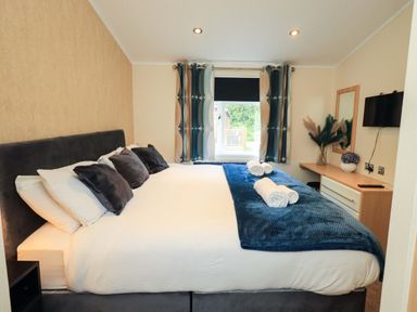A bedroom with a large bed and furnishings at Rydal Lodge Grasmere 24, White Cross Bay near Windermere