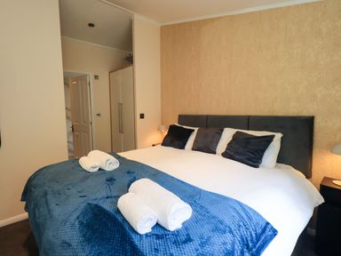 A bedroom with a bed and towels at Rydal Lodge Grasmere 24, White Cross Bay near Windermere
