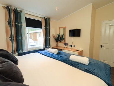 A bedroom with a bed and television at Rydal Lodge in Grasmere 24, White Cross Bay near Windermere