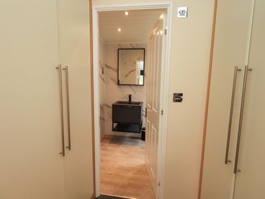 A bathroom with a mirror and sink at Rydal Lodge, Grasmere 24, White Cross Bay near Windermere