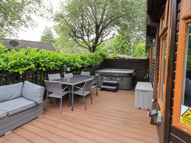 An outdoor space with a hot tub and seating at Rydal Lodge Grasmere 24, White Cross Bay near Windermere