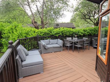 An outdoor space with a sofa and dining table at Rydal Lodge Grasmere 24, White Cross Bay near Windermere