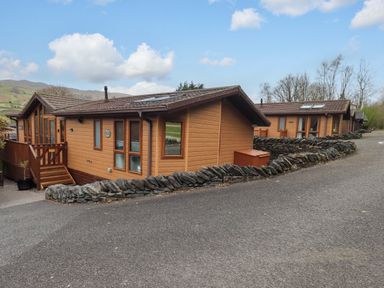 Two wooden cabins surrounded by stone walls at Elder Lodge Kirkstone 5 Limefitt Park near Windermere