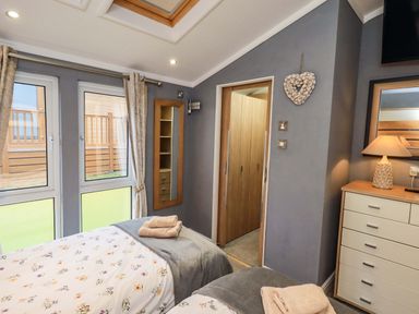A bedroom with two beds and a wardrobe at Elder Lodge, Kirkstone 5, Limefitt Park near Windermere