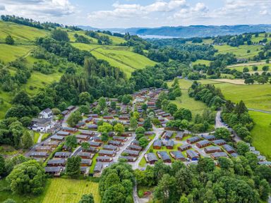 Aerial view of a holiday park with multiple cabins surrounded by trees and green hills at Walkers Retreat Lodge Fellside 5 Limefitt Park near Windermere